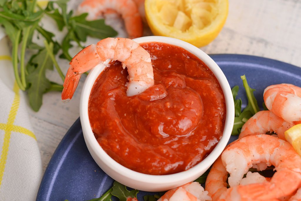 shrimp dipped in cocktail sauce