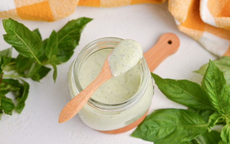 wooden spoon with creamy basil pesto sauce