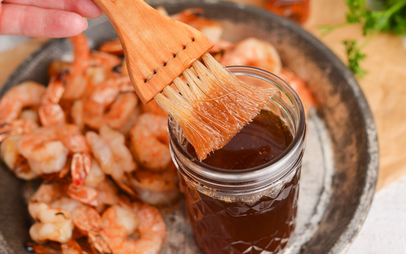 brush dipping into whiskey glaze jar