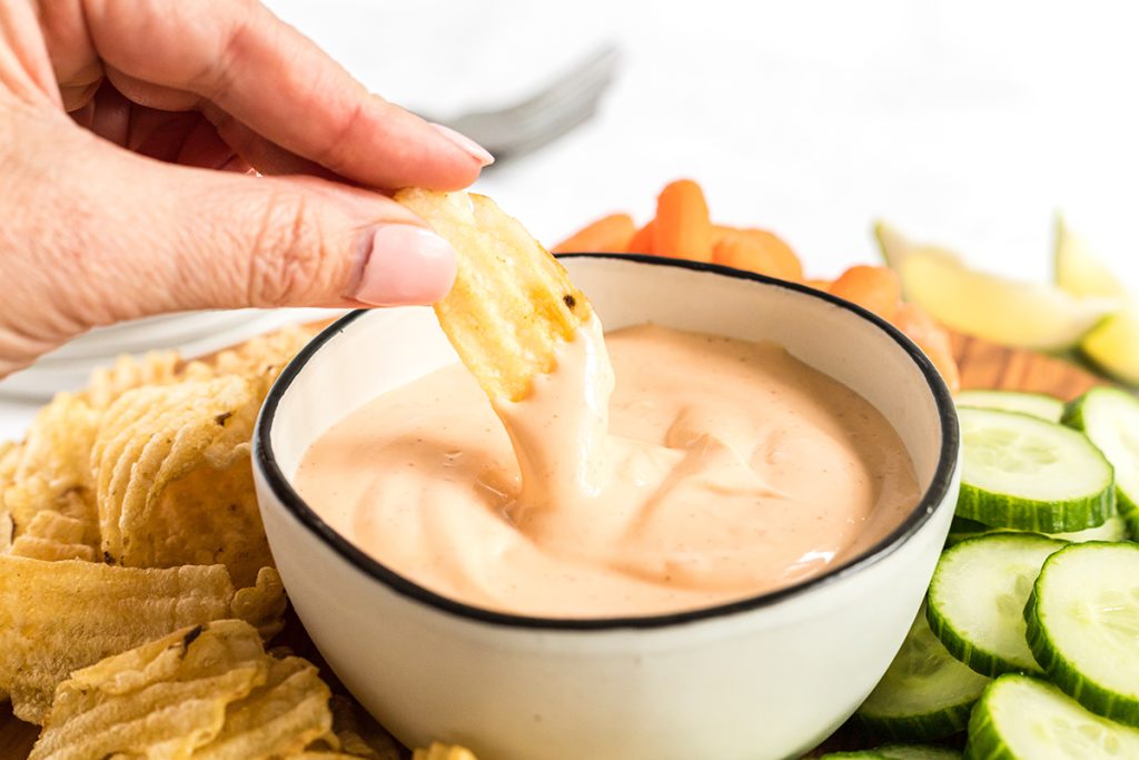 chip dipping into spicy aioli