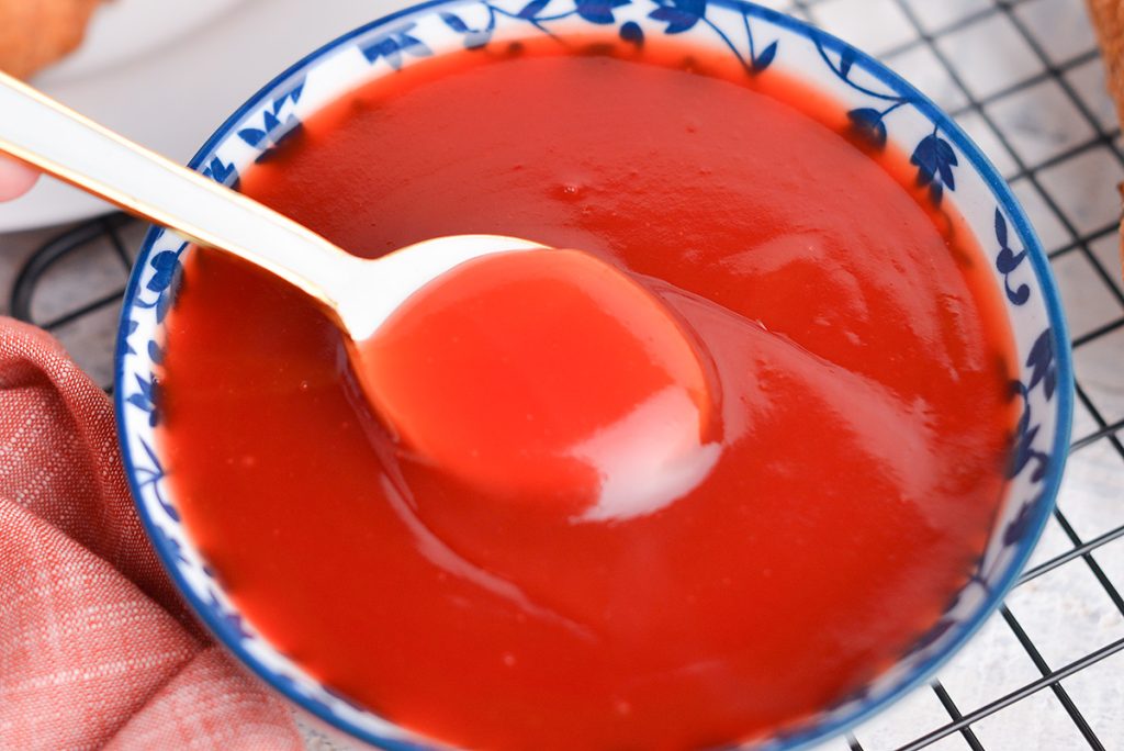 spoon dipped into sweet and sour sauce