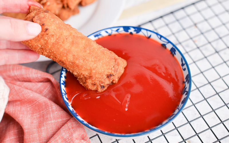 egg roll dipped into sweet and sour sauce