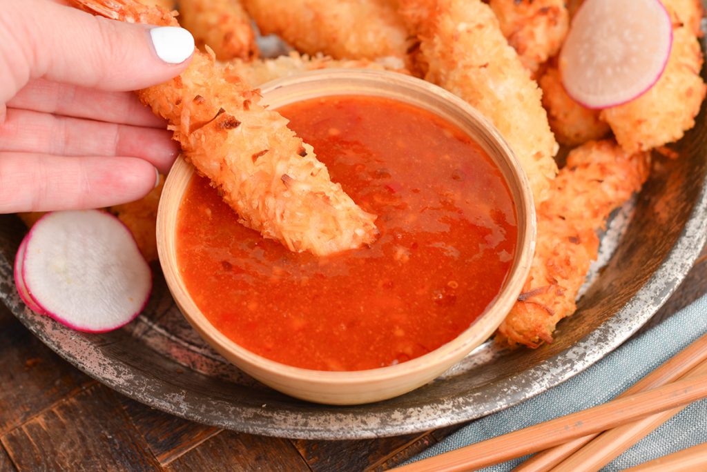 shrimp dipping into coconut dipping sauce
