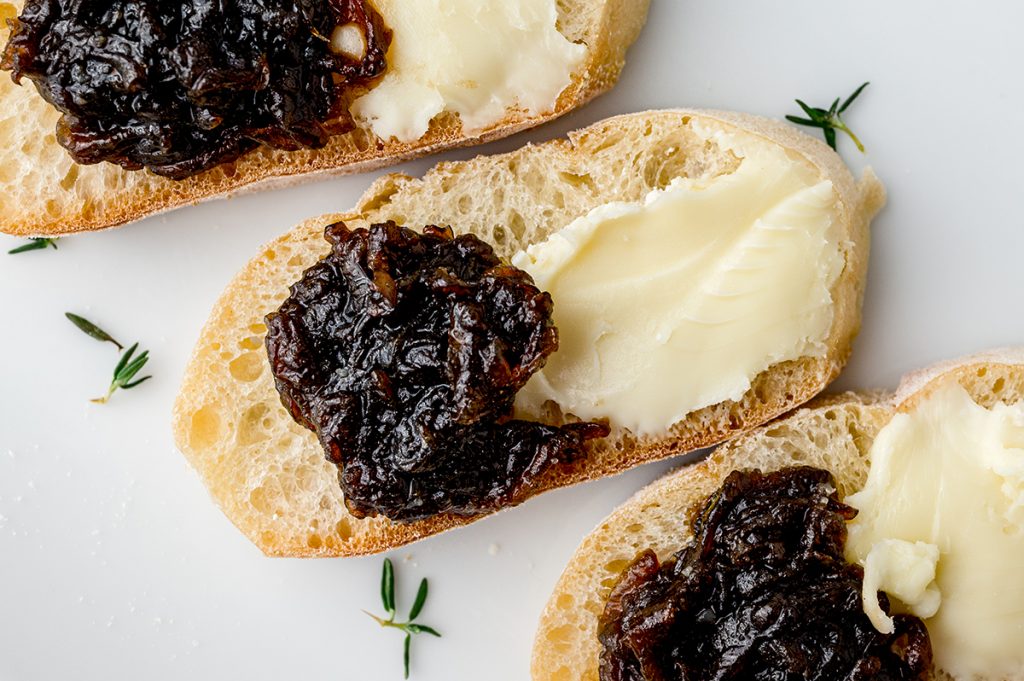 close up of caramelized onion jam with cheese on a slice of bread
