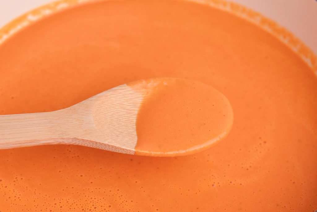 pink sauce for pasta on a wooden spoon