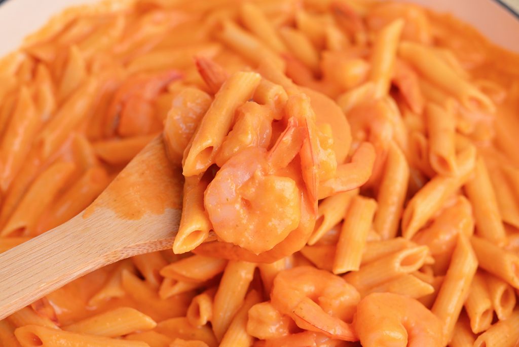 shrimp and pasta on a wooden spoon