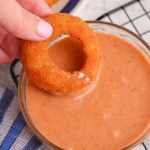 onion ring dipped into campfire sauce