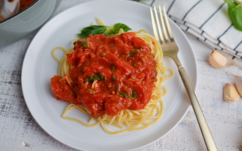 pasta sauce over plate of pasta