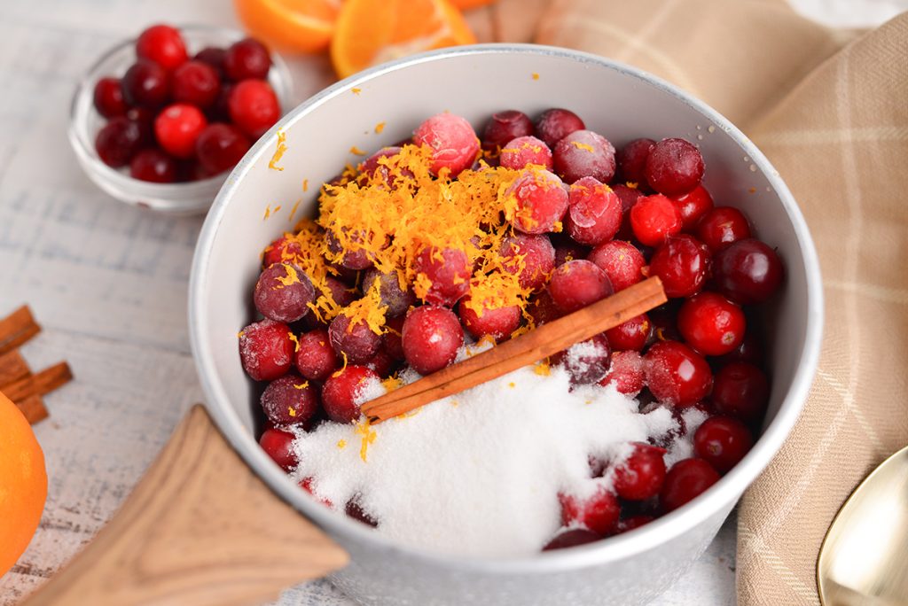 angled shot of cranberry orange sauce ingredients in a pan