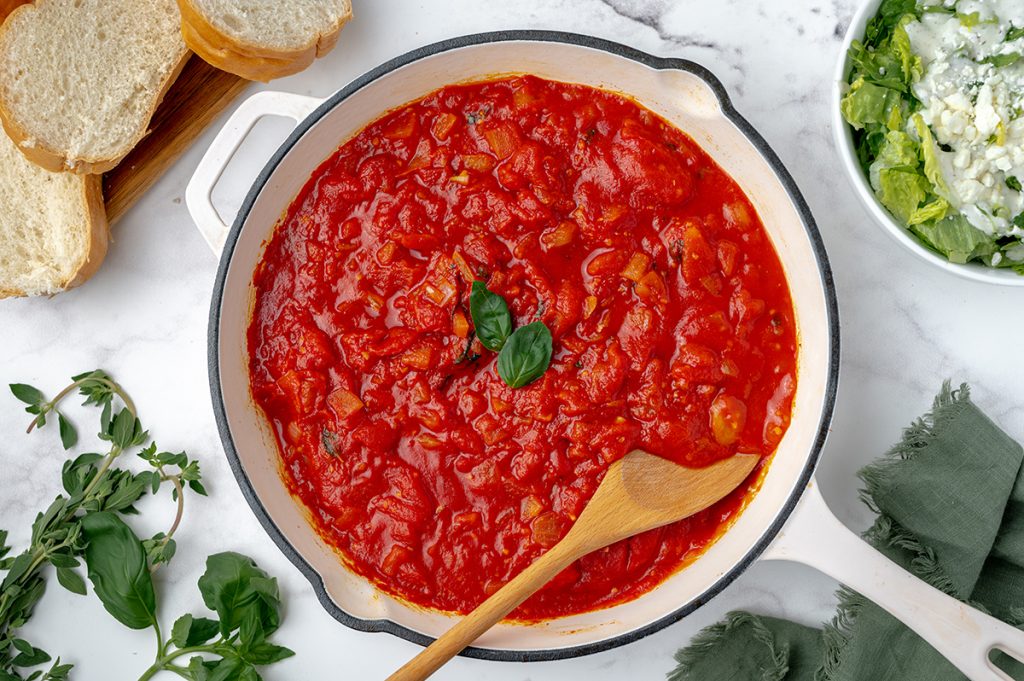 pan of spicy marinara with wooden spoon