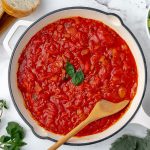 pan of spicy marinara with wooden spoon