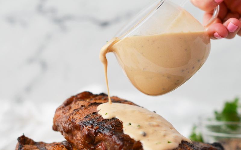 creamy peppercorn sauce poured on steak