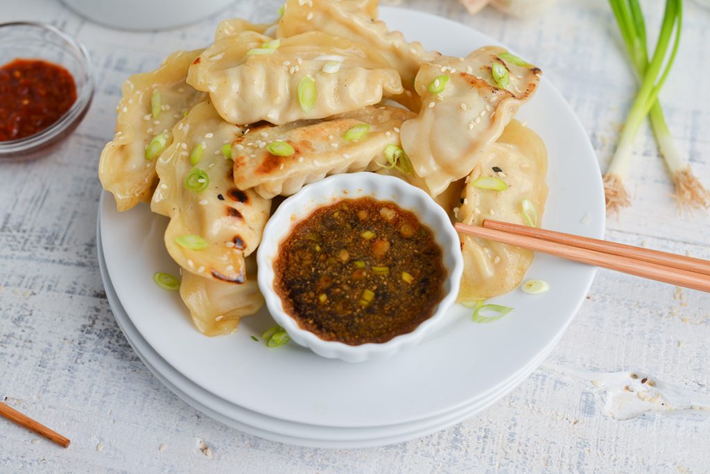 bowl of pot sticker sauce on plate of pot stickers