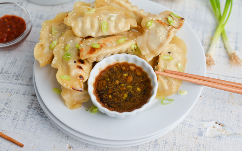 bowl of pot sticker sauce on plate of pot stickers