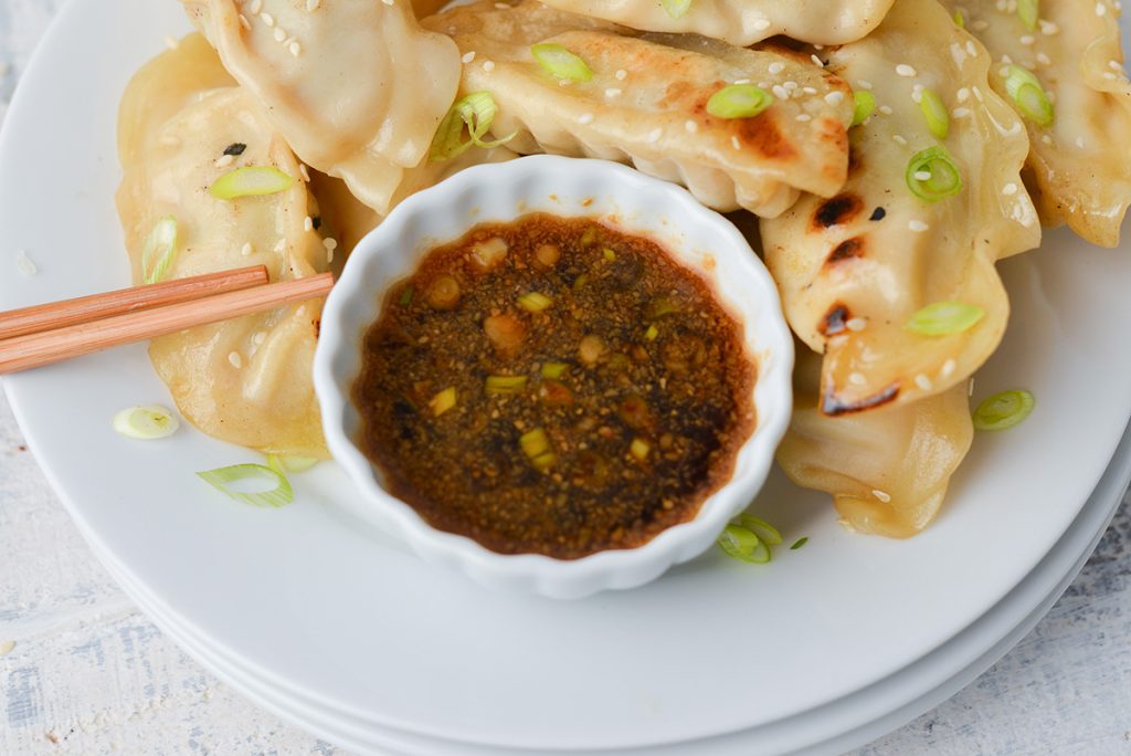 angled shot of small white bowl of pot sticker sauce