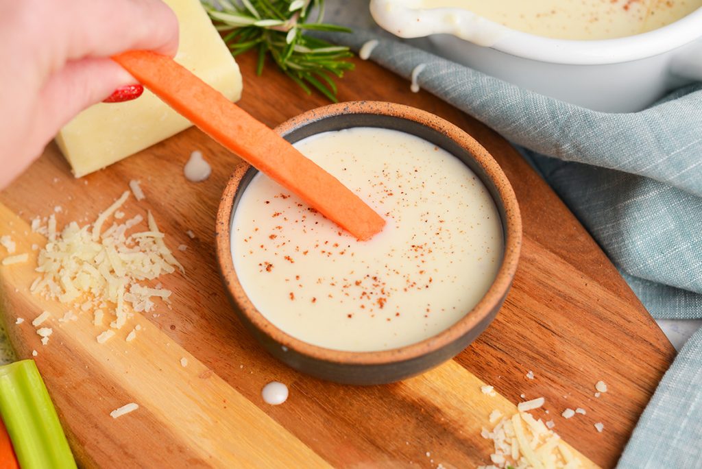 carrot stick dipping into white sauce