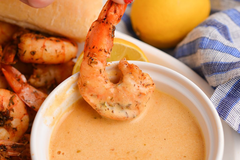 shrimp dipping into seafood sauce