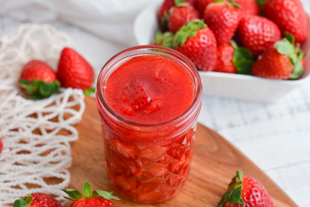 angled shot of jar of fresh strawberry sauce