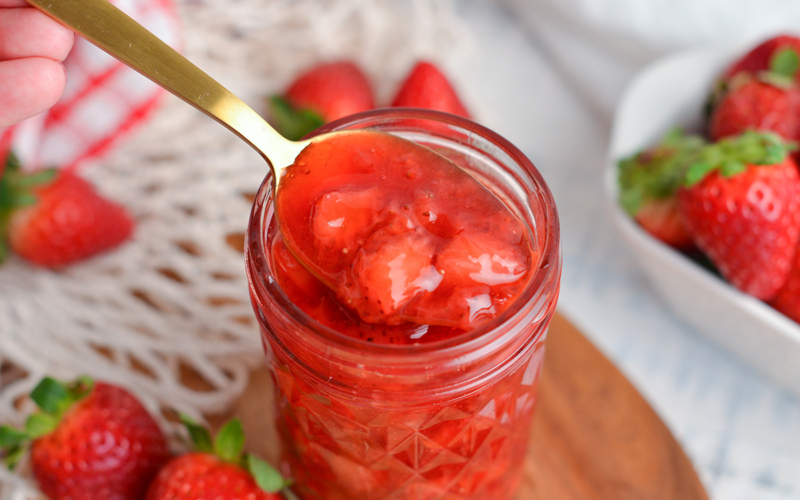 spoon in jar of strawberry topping