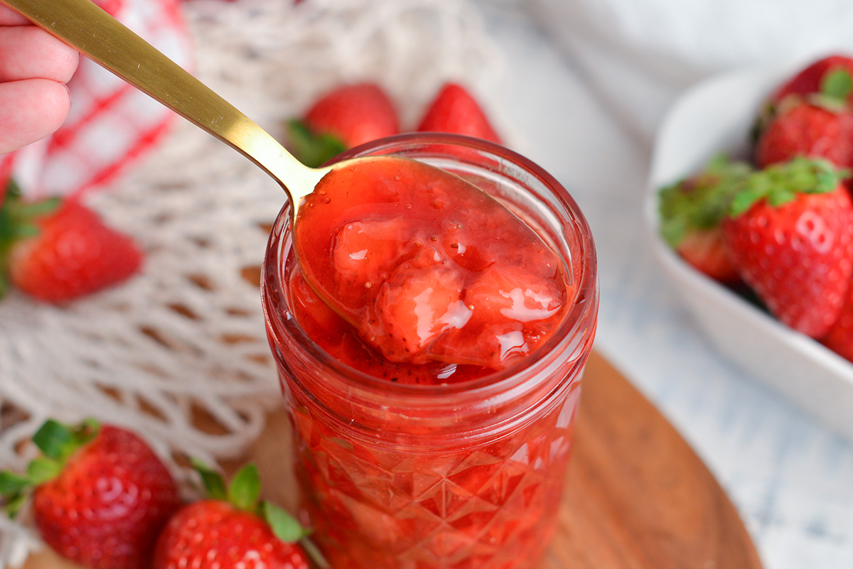 spoon in jar of strawberry topping