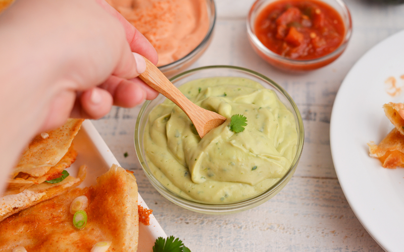 spoon dipping into bowl of sauce