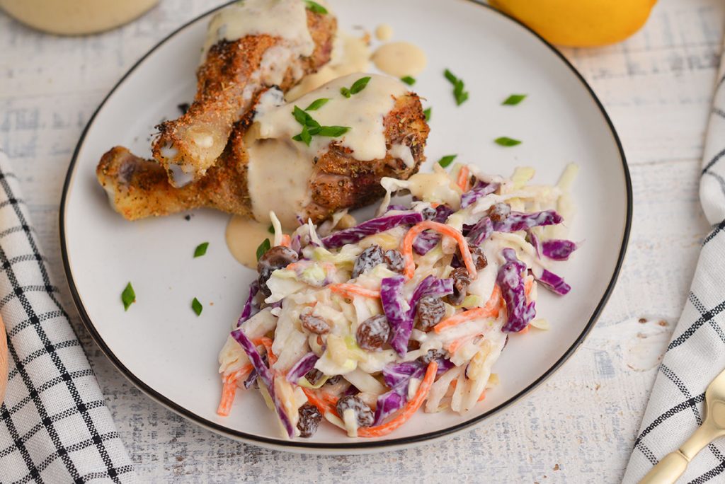 plate of chicken drumsticks with coleslaw