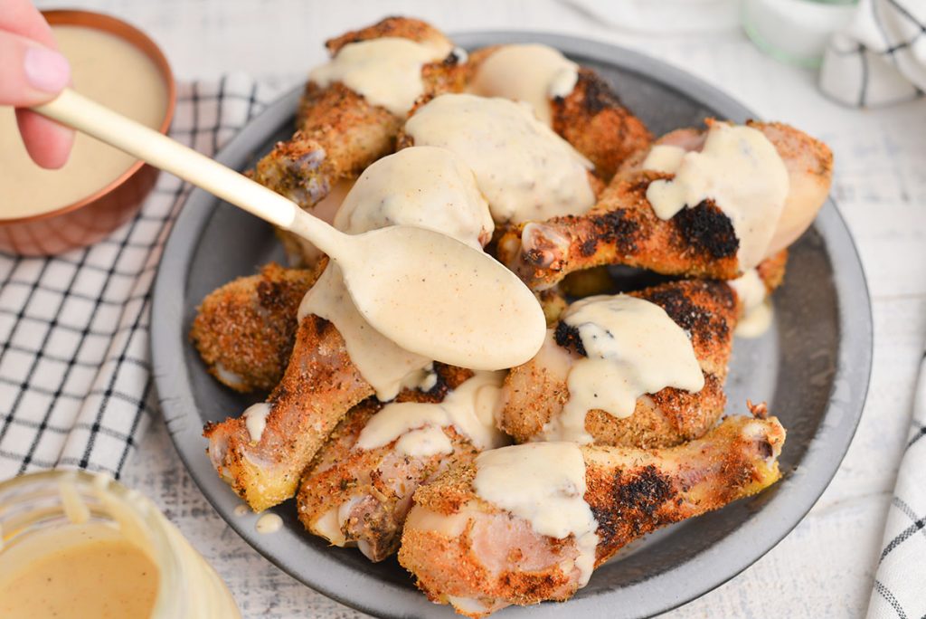 plate of chicken with alabama white sauce spooned onto it