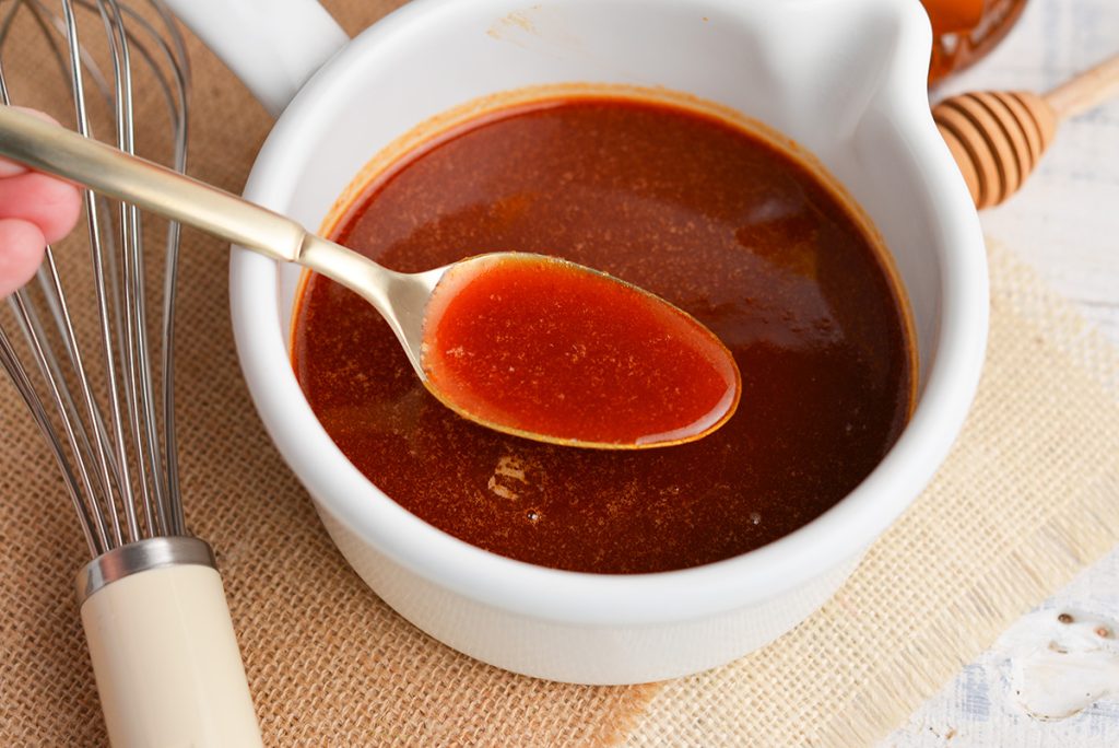 spoon in bowl of honey sriracha sauce