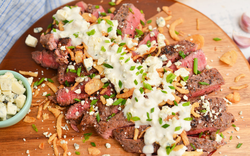 angled shot of blue cheese sauce drizzled on steak