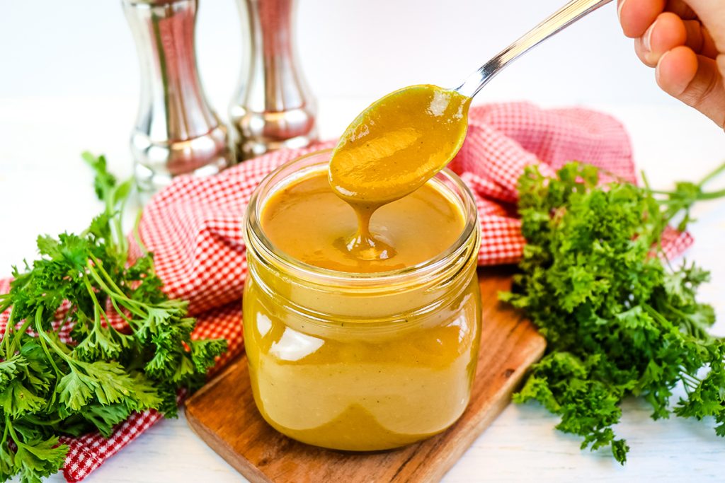 spoon in jar of golden bbq sauce