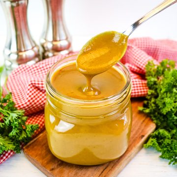 spoon in jar of golden bbq sauce