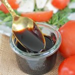 spoon dipping into jar of balsamic glaze