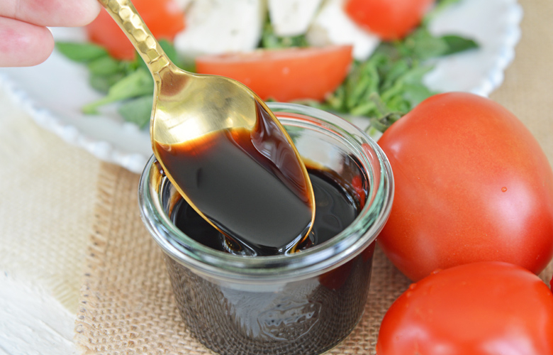 spoon dipping into jar of balsamic glaze