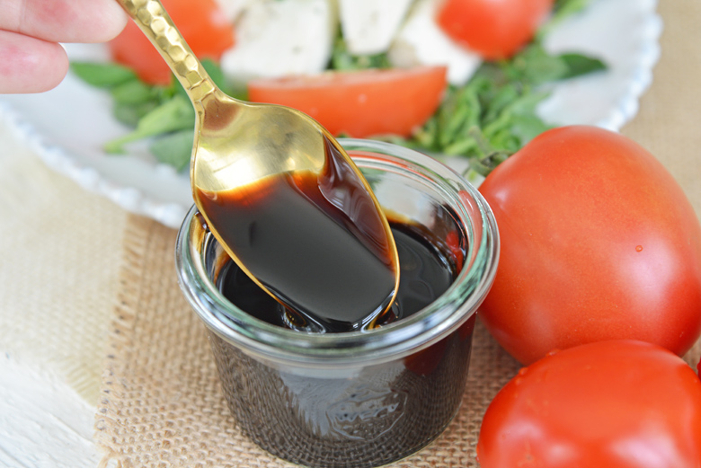 spoon dipping into jar of balsamic glaze