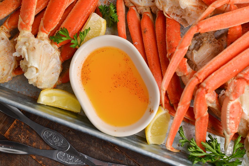 overhead shot of bowl of crab butter on tray of crab