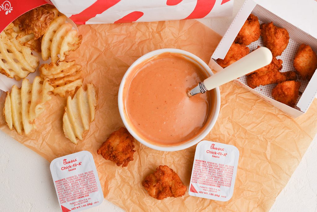 overhead shot of chick-fil-sauce in a bowl with nuggets and fries