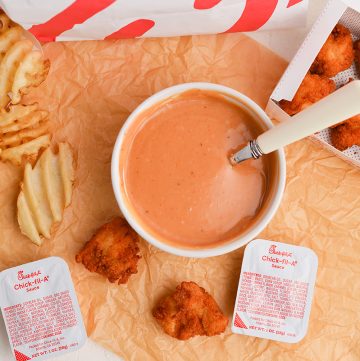 overhead shot of chick-fil-sauce in a bowl with nuggets and fries