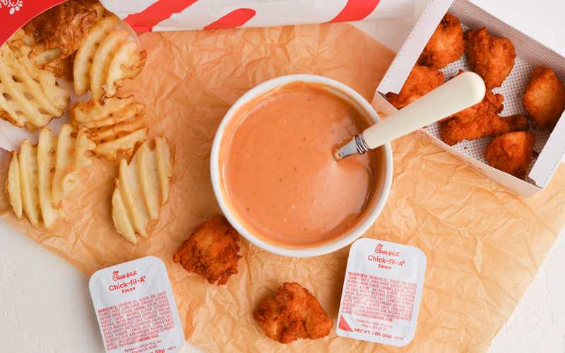 overhead shot of chick-fil-sauce in a bowl with nuggets and fries