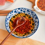 angled shot of spoon in bowl of chili oil
