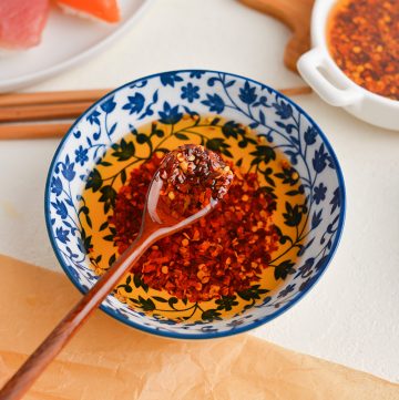 angled shot of spoon in bowl of chili oil