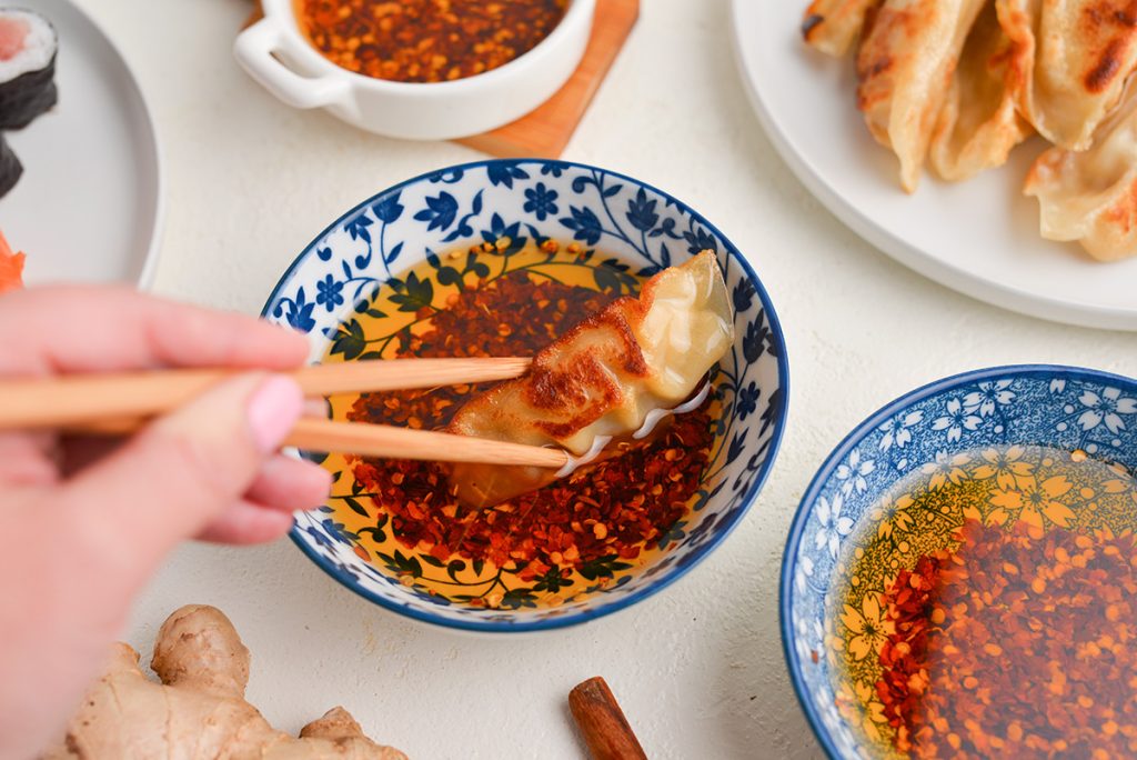 potsticker dipped into bowl of spicy oil