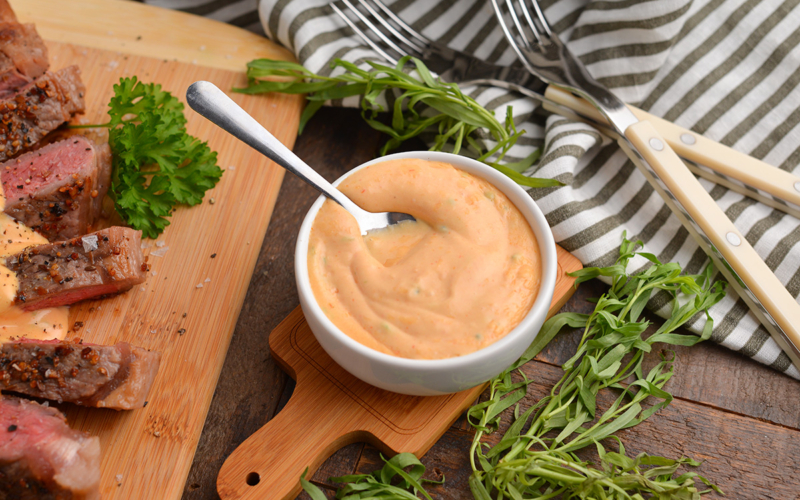 angled shot of spoon in bowl of french choron sauce