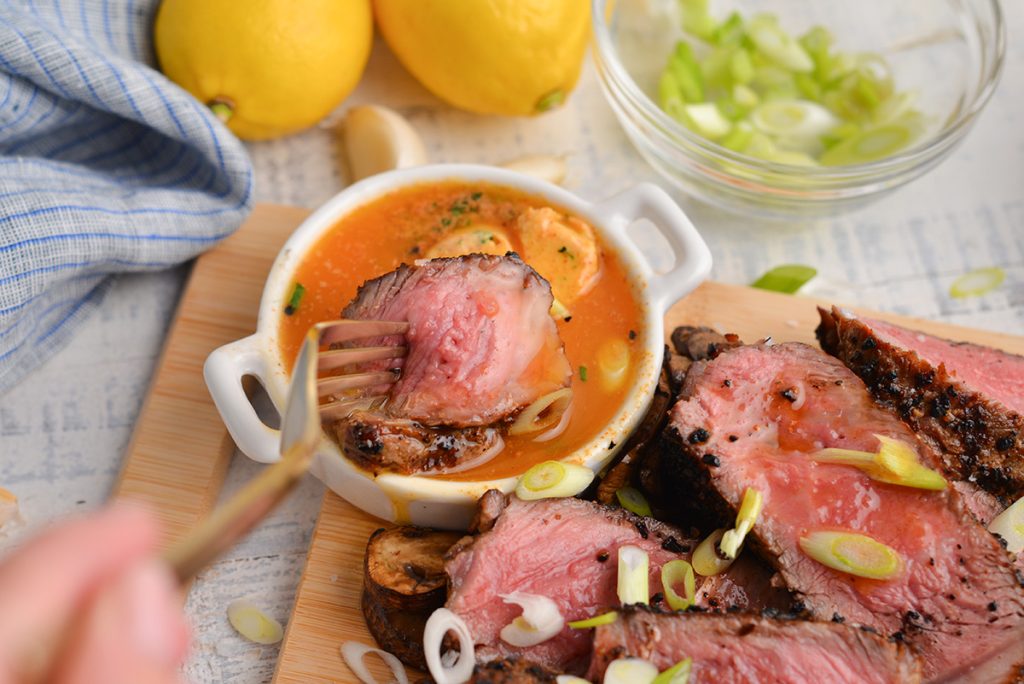 bite of steak dipping into melted cowboy butter
