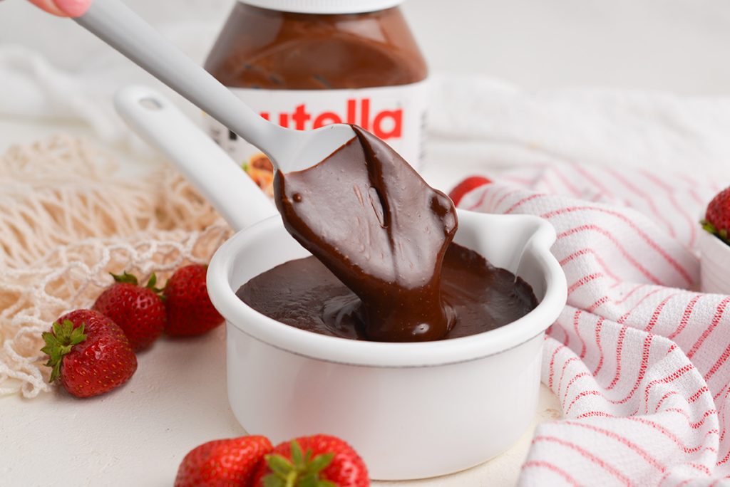 angled shot of spatula in bowl of nutella sauce