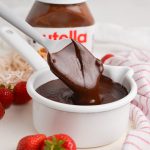 angled shot of spatula in bowl of nutella sauce