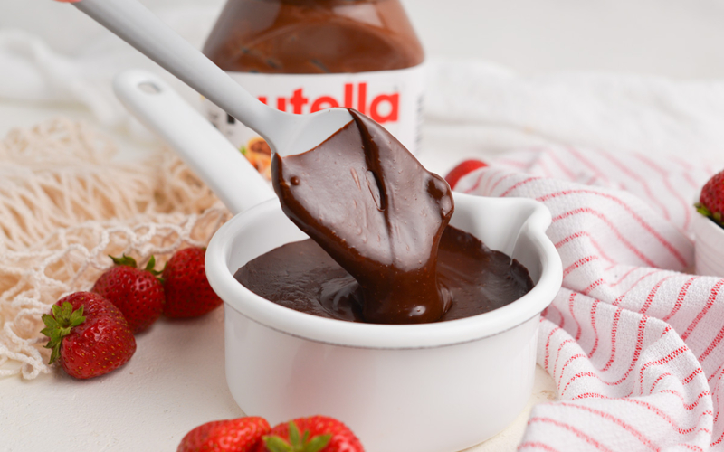 angled shot of spatula in bowl of nutella sauce