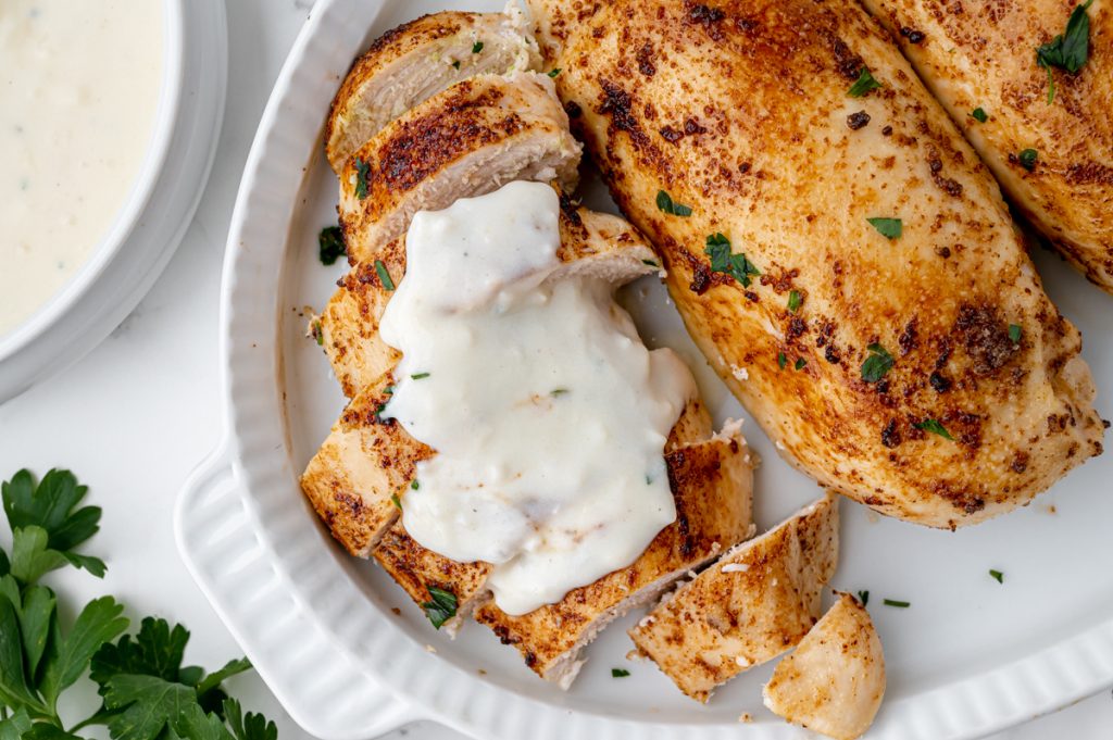 sliced chicken topped with white garlic sauce