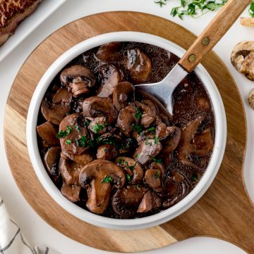 overhead shot of bowl of red wine mushroom sauce with spoon in it