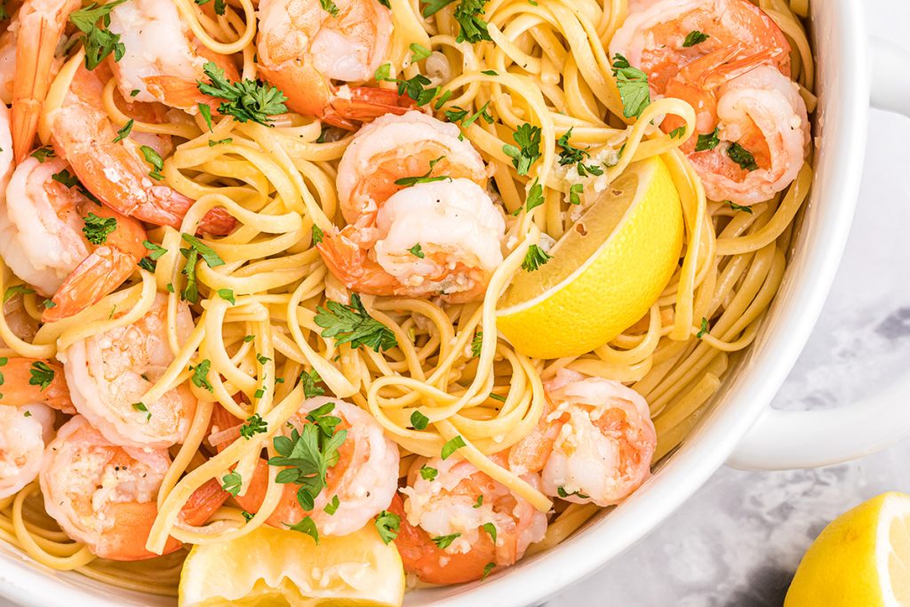 overhead shot of bowl of pasta with shrimp and lemon