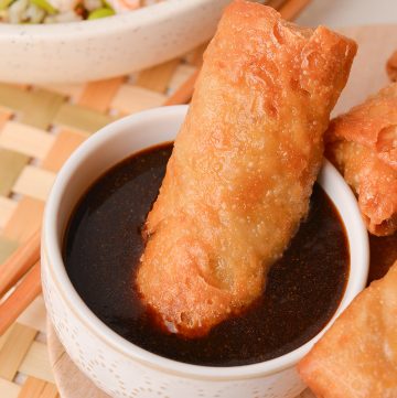 egg roll in bowl of sauce